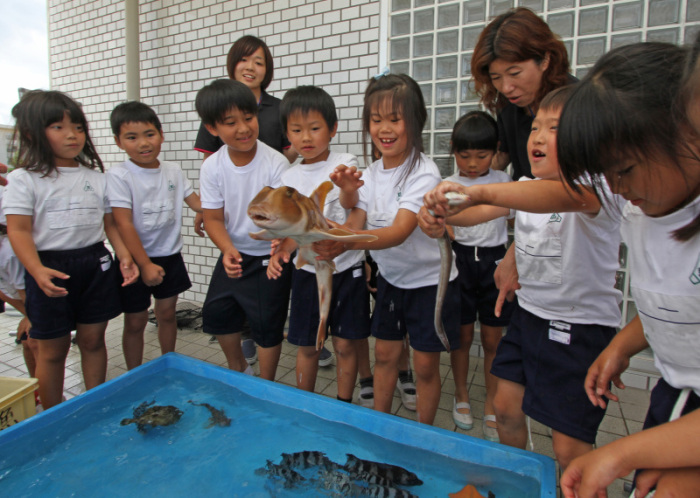 児童が魚をつかんでいる様子の画像