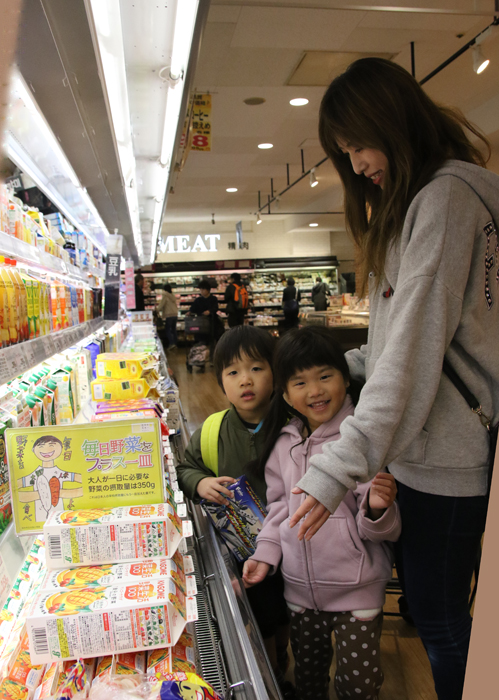 POPの前で商品を手にする親子連れ