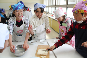 楽しそうに豆腐を切る児童の写真