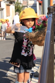 子供が植え替えた花に水やりをしている写真