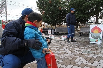 ホースを持ち消火体験をする子どもの写真