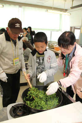 地域の人とお茶を煎る児童達を撮影した画像