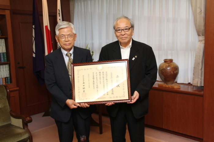 表彰状を持つ中西理事長と木本市長