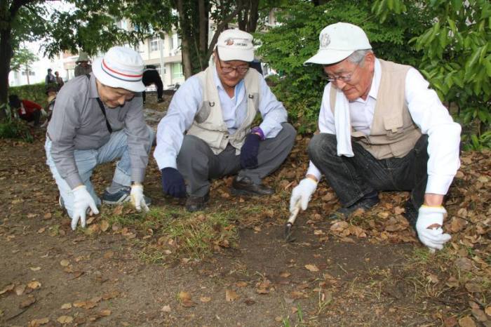 (写真)草刈りをする参加者