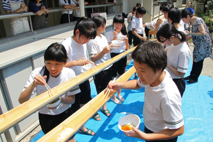 流しそうめんを楽しむ生徒ら