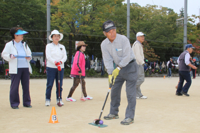 カップに向けて狙いを定める市民の画像