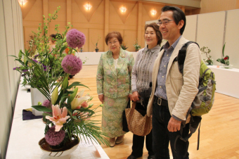 笑顔で生花を鑑賞する市民の写真