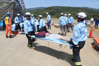 訓練で救助隊が負傷者を担架で運ぶ様子の画像