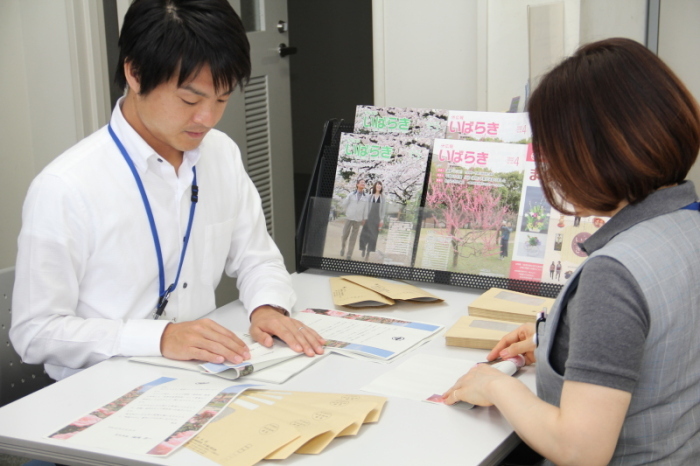 職員が熊本への災害支援寄附金のお礼状を封筒に詰めている様子の画像