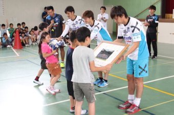 ガンバ大阪の選手から記念品を贈呈される児童たちの画像