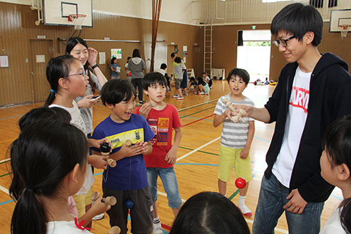 留学生にけん玉を伝える児童たちの画像