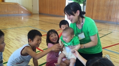 赤ちゃんとふれあう児童たちの写真