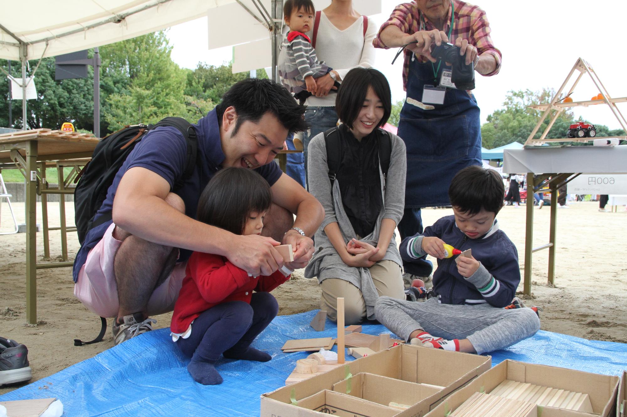 積み木で工作体験をする親子