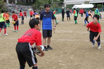 中学生の練習を見守る松山博明さん