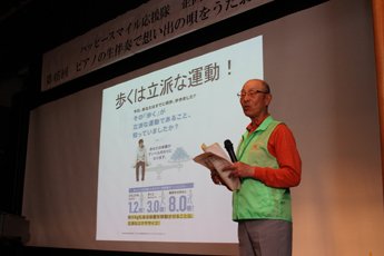 檀上で健康講和を披露するハッピースマイル応援隊スタッフ