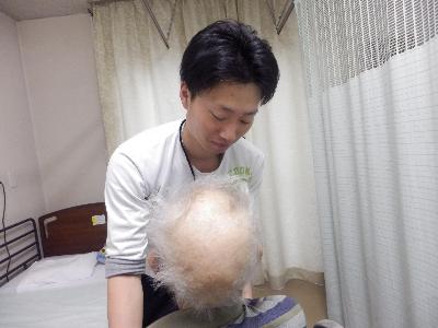 介護職員が男性の利用者を介護している写真