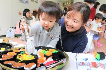 おみせやさんごっこする親子