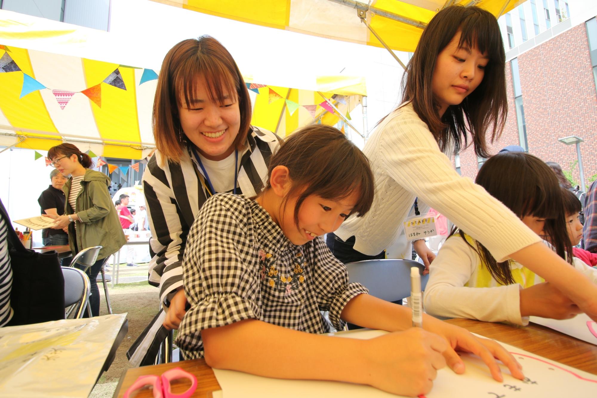 ポーチをつくる子どもと大学生