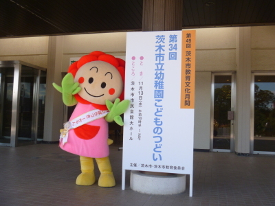 第34回茨木市幼稚園こどものつどいと書かれた看板の横でポーズをとるいばらっきーちゃんの画像