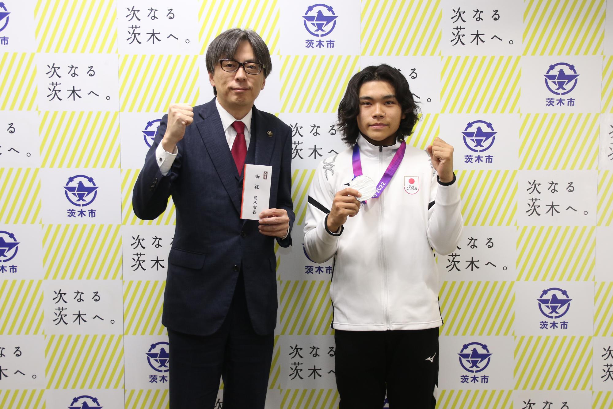 ガッツポーズをする川原大和さんと市長の写真