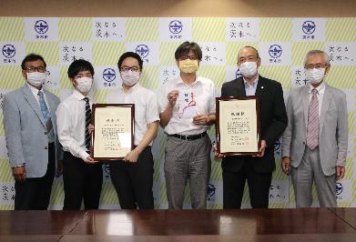 茨木ロータリークラブ、茨木ローターアクトクラブの皆様が感謝状を持ち、市長が目録を持って並んでいる写真