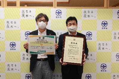 明治安田生命保険相互会社大阪北支社様が感謝状を持ち、市長か目録を持って並んでいる写真
