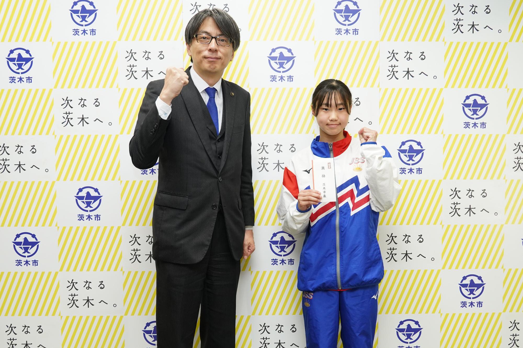 ガッツポーズをする辻本澪菜さんと市長の写真