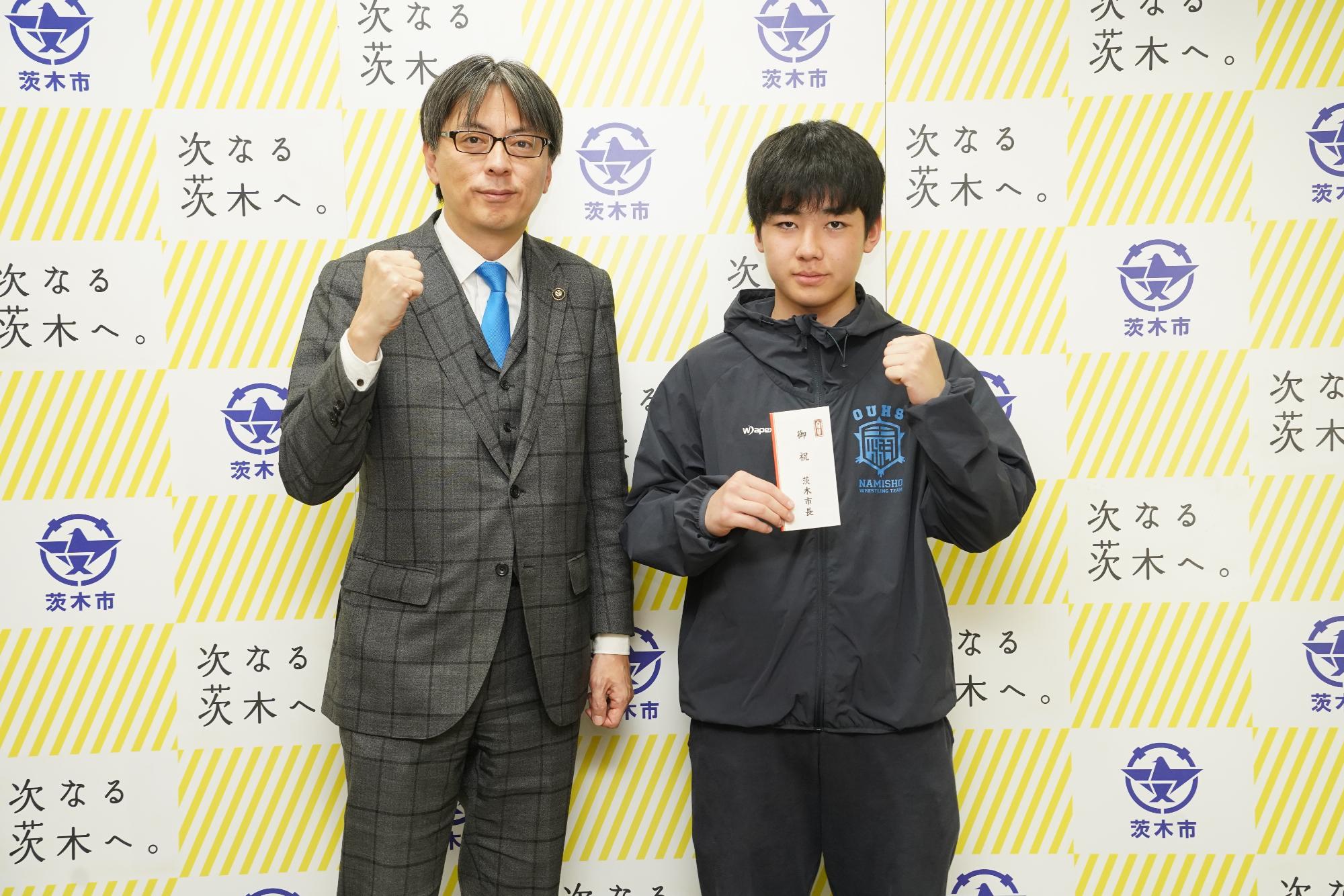 ガッツポーズをする選手と市長の写真