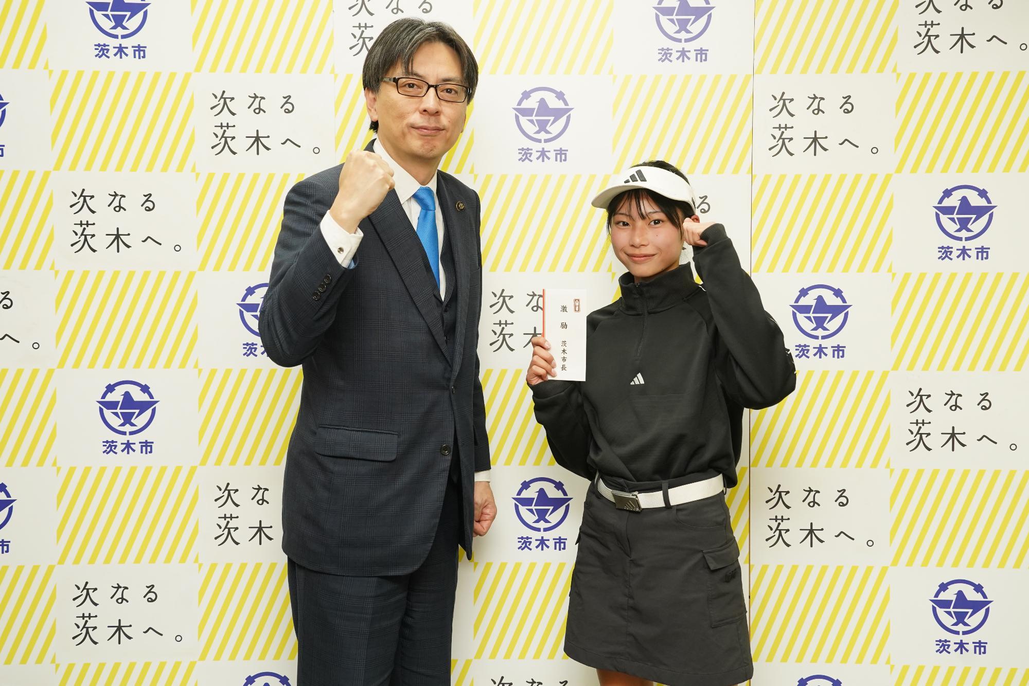 ガッツポーズをする選手と市長の写真