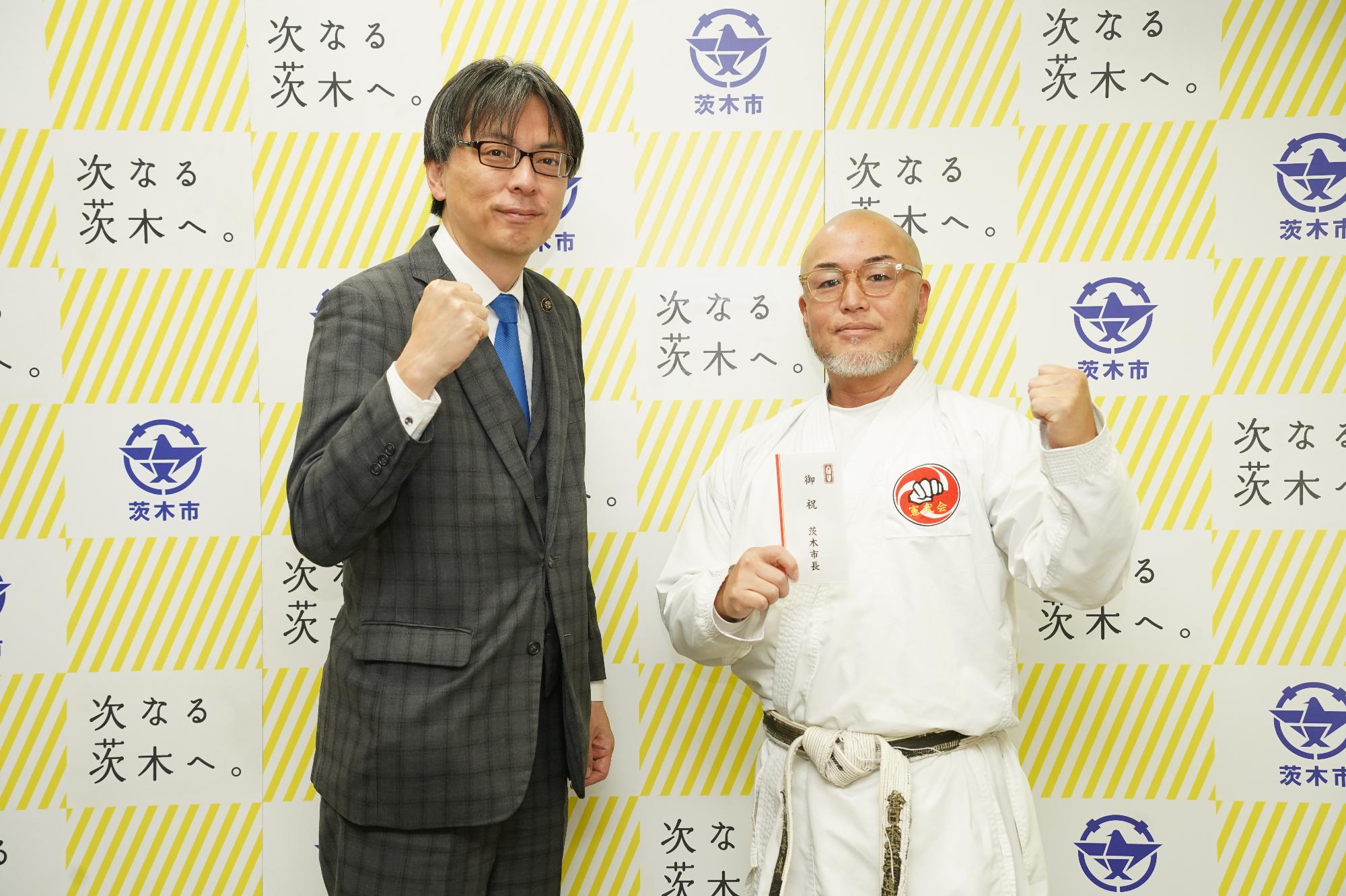 ガッツポーズをする選手と市長の写真