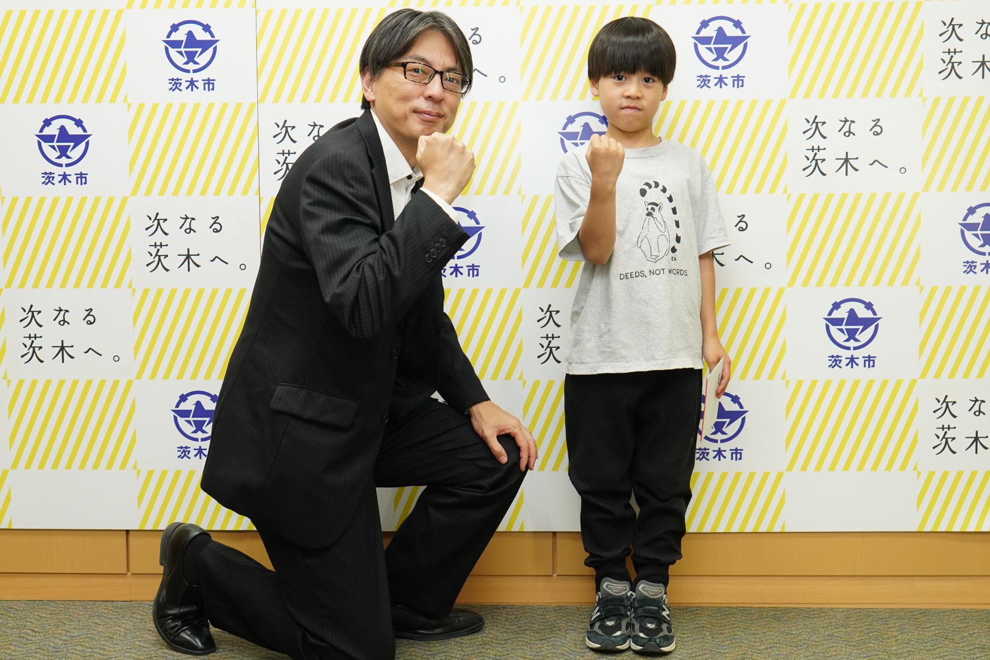 ガッツポーズをする長尾歩武さんと市長の写真