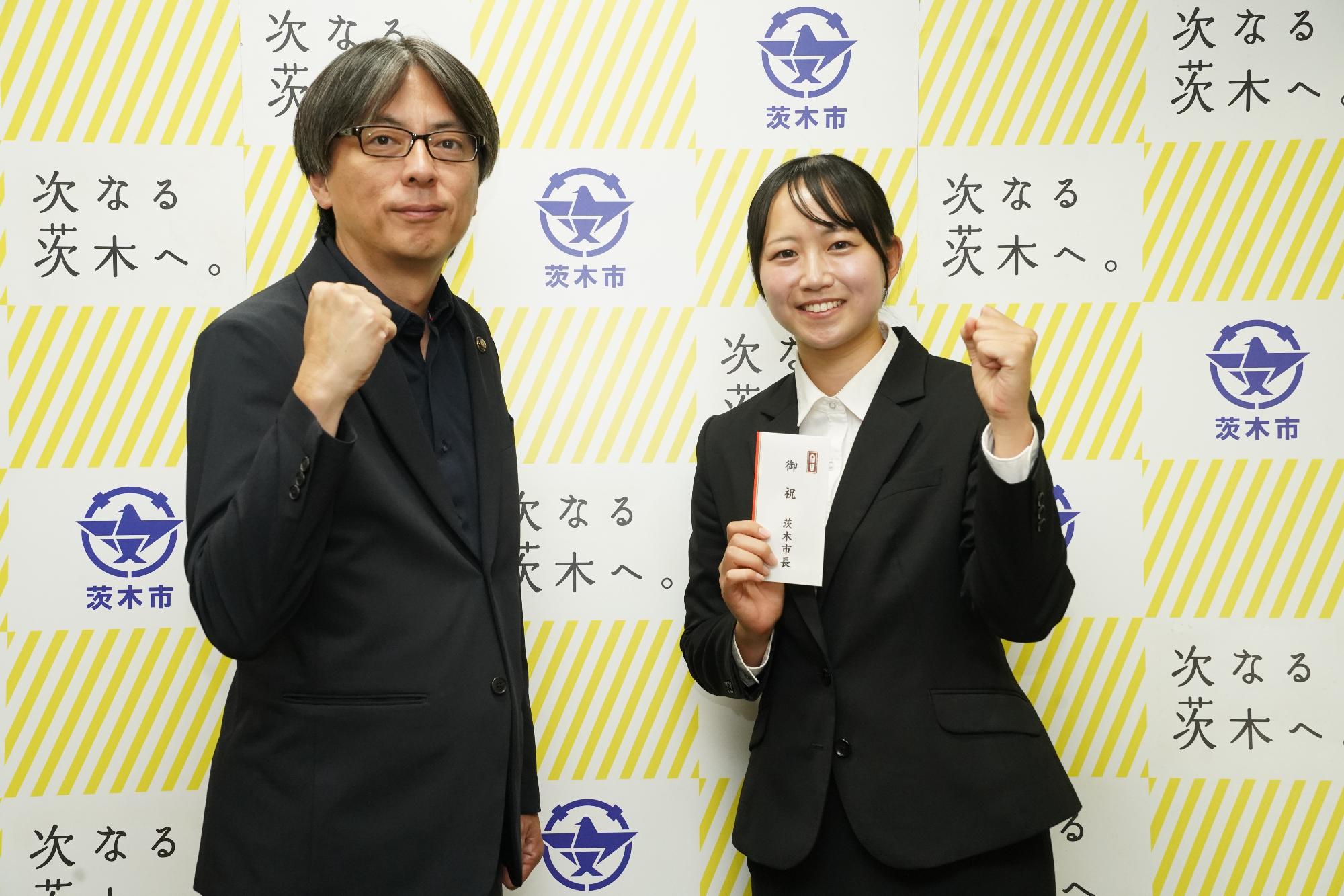 ガッツポーズをする選手と市長の写真