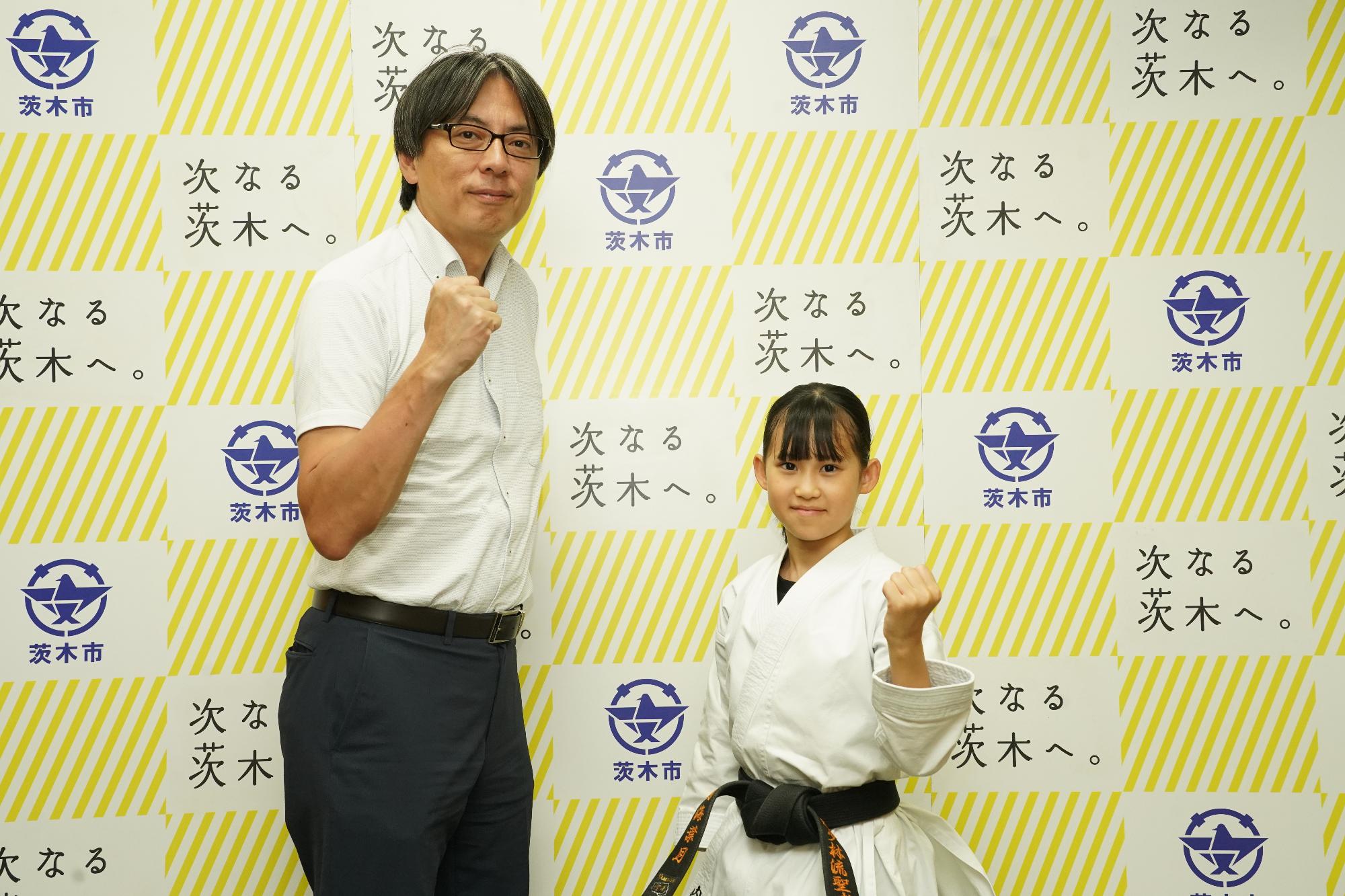 ガッツポーズをする選手と市長の写真