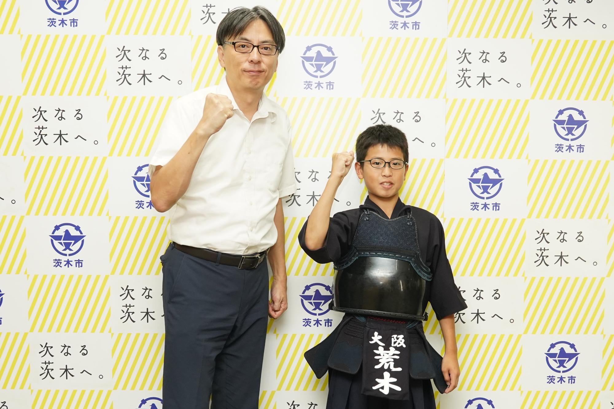 ガッツポーズをする選手と市長の写真