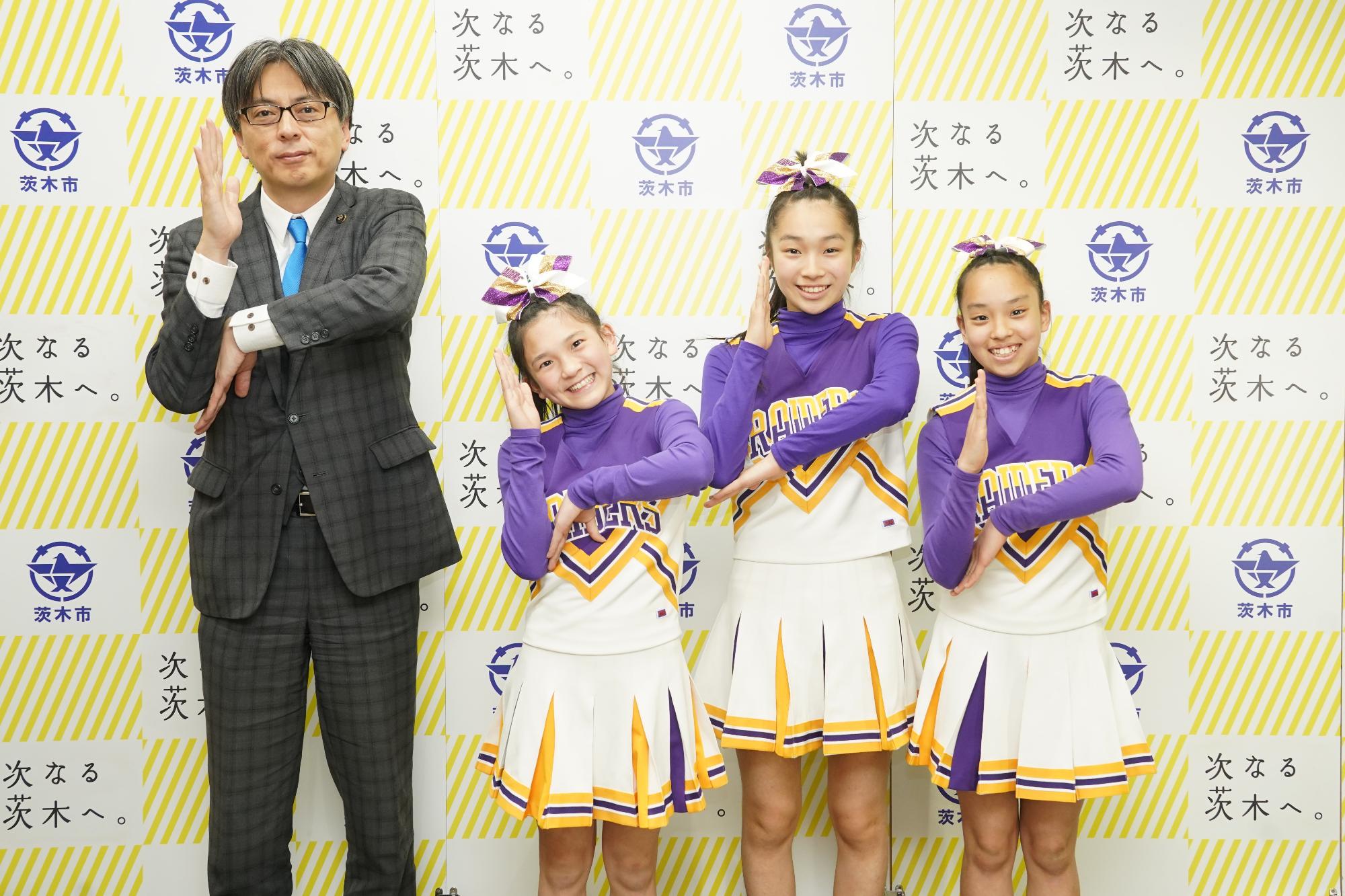 ポーズをとる選手3名と市長の写真