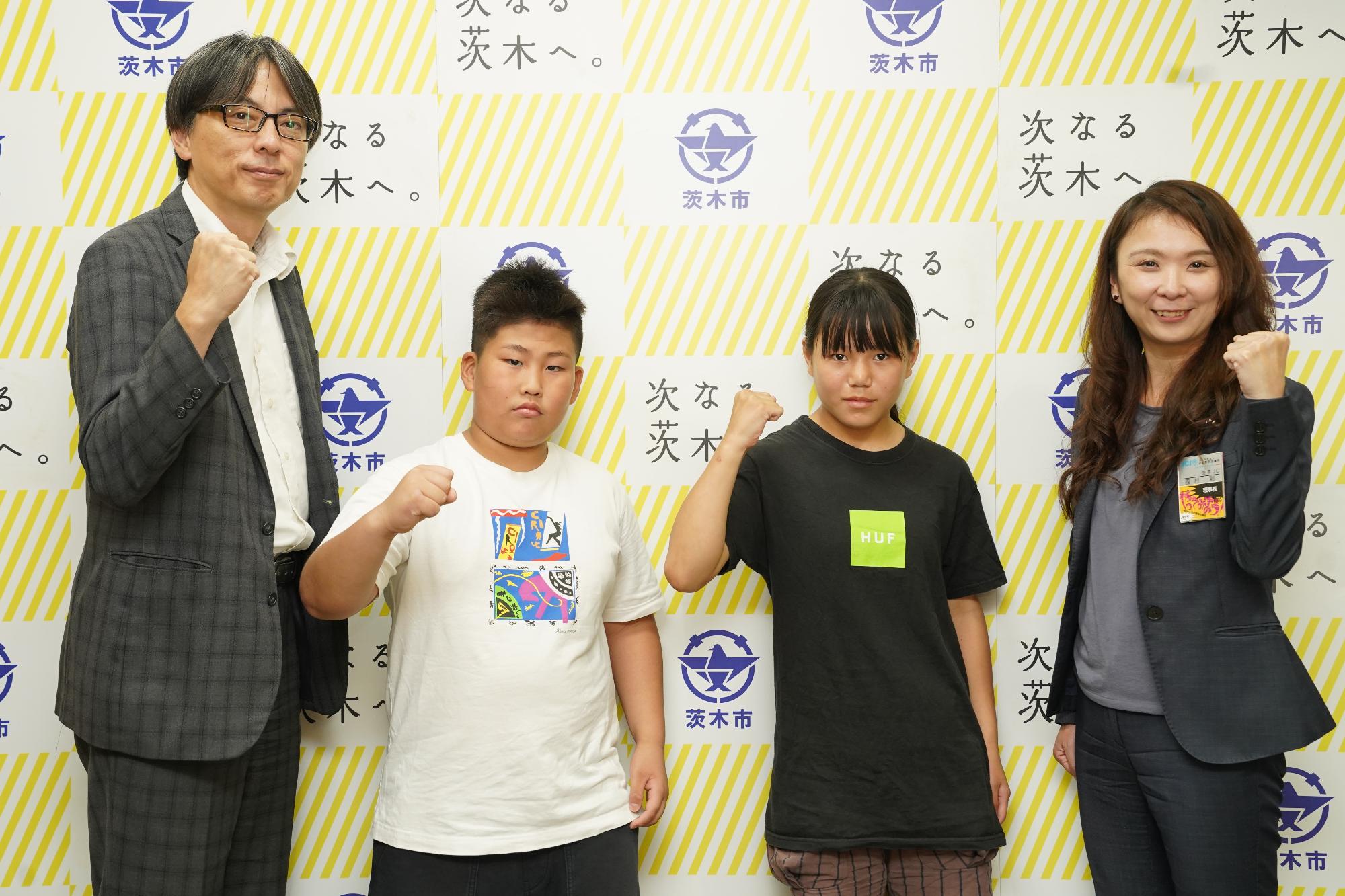 ガッツポーズをする選手2名、関係者と市長の写真