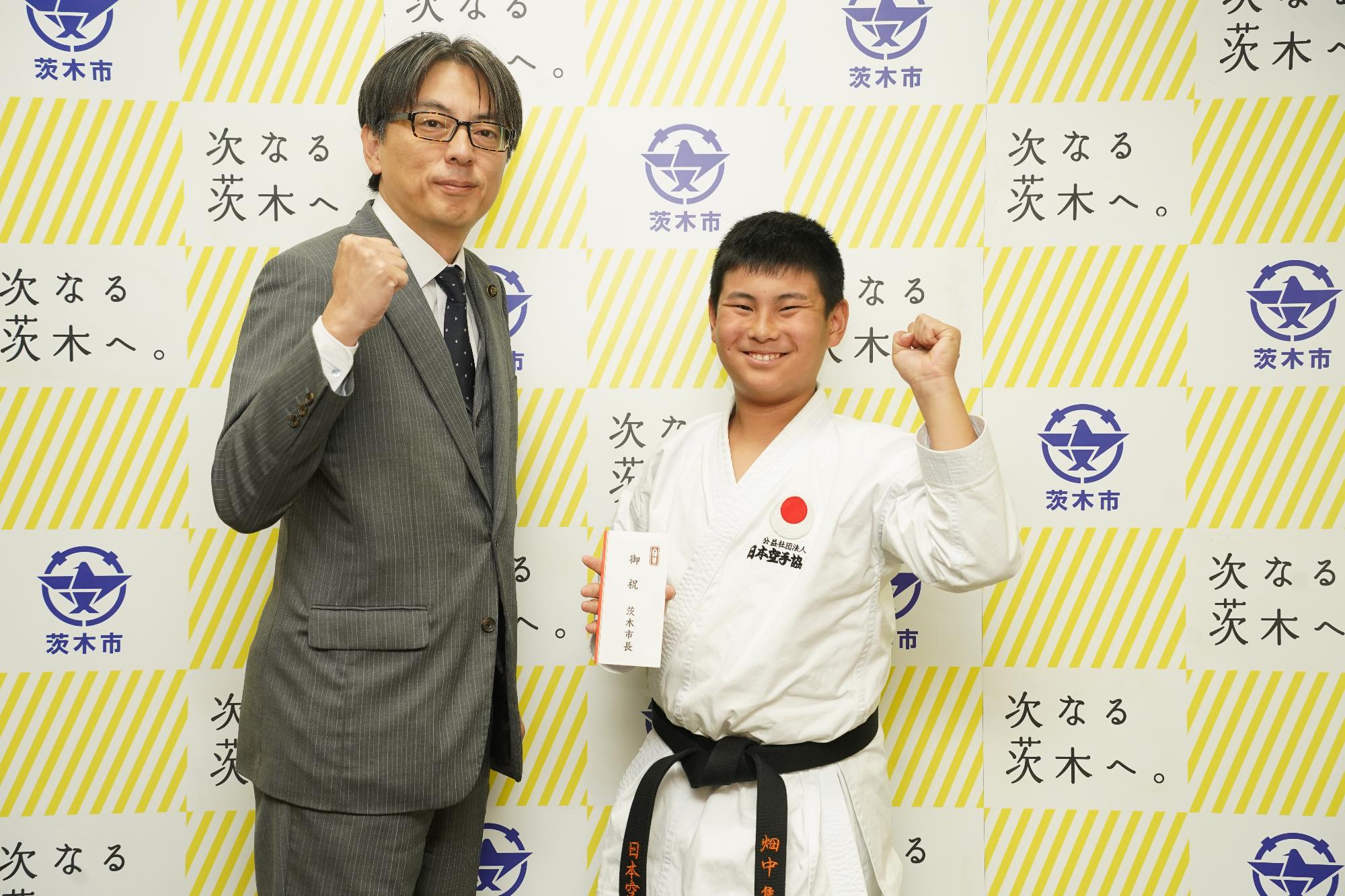 ガッツポーズをする選手と市長の写真