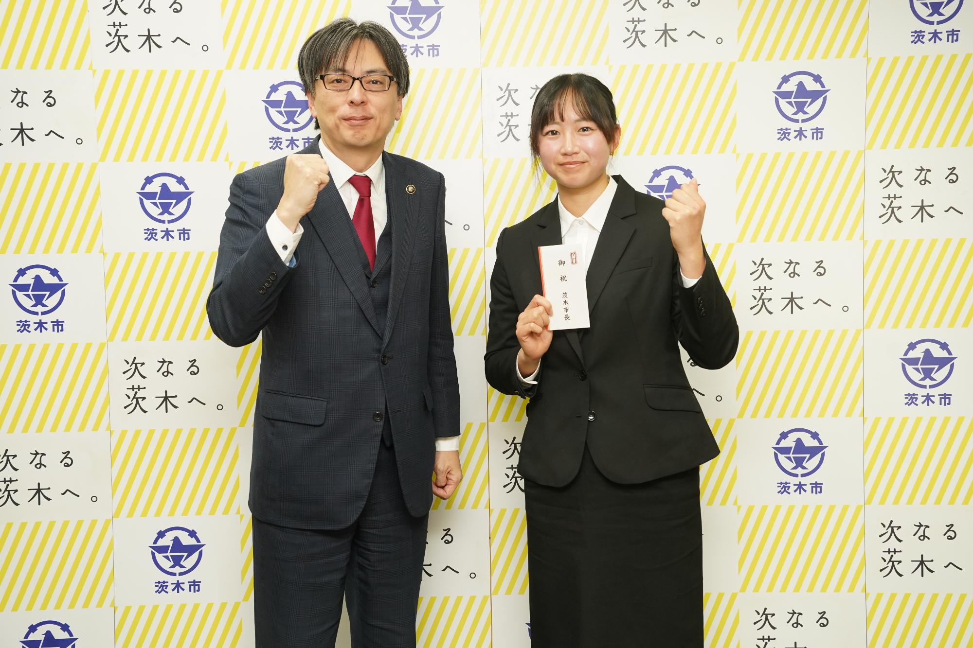 ガッツポーズをする選手と市長の写真