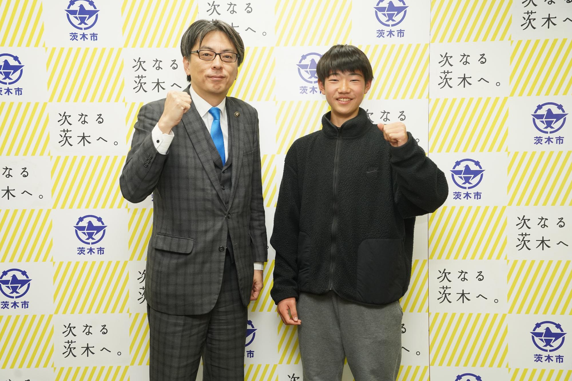 ガッツポーズをする選手と市長の写真