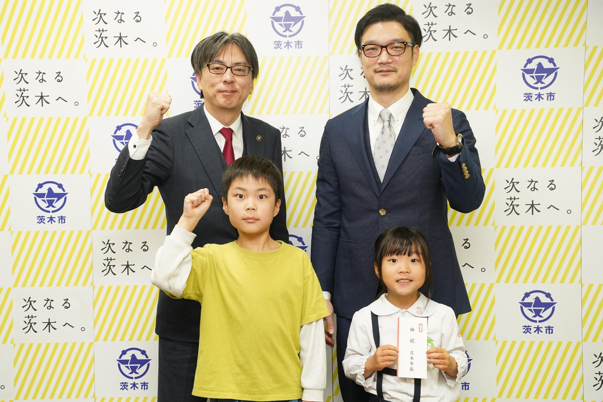 ガッツポーズをする選手、関係者と市長の写真