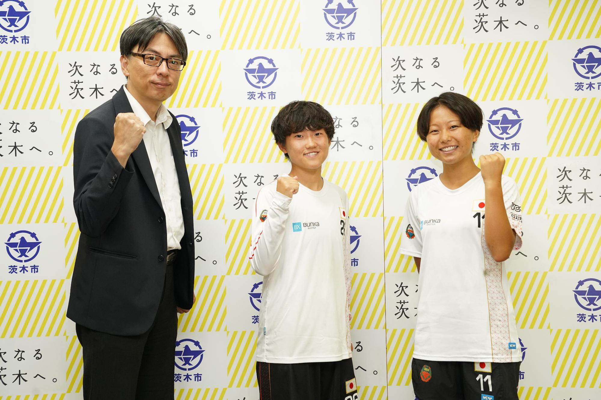ガッツポーズをする選手2名と市長の写真