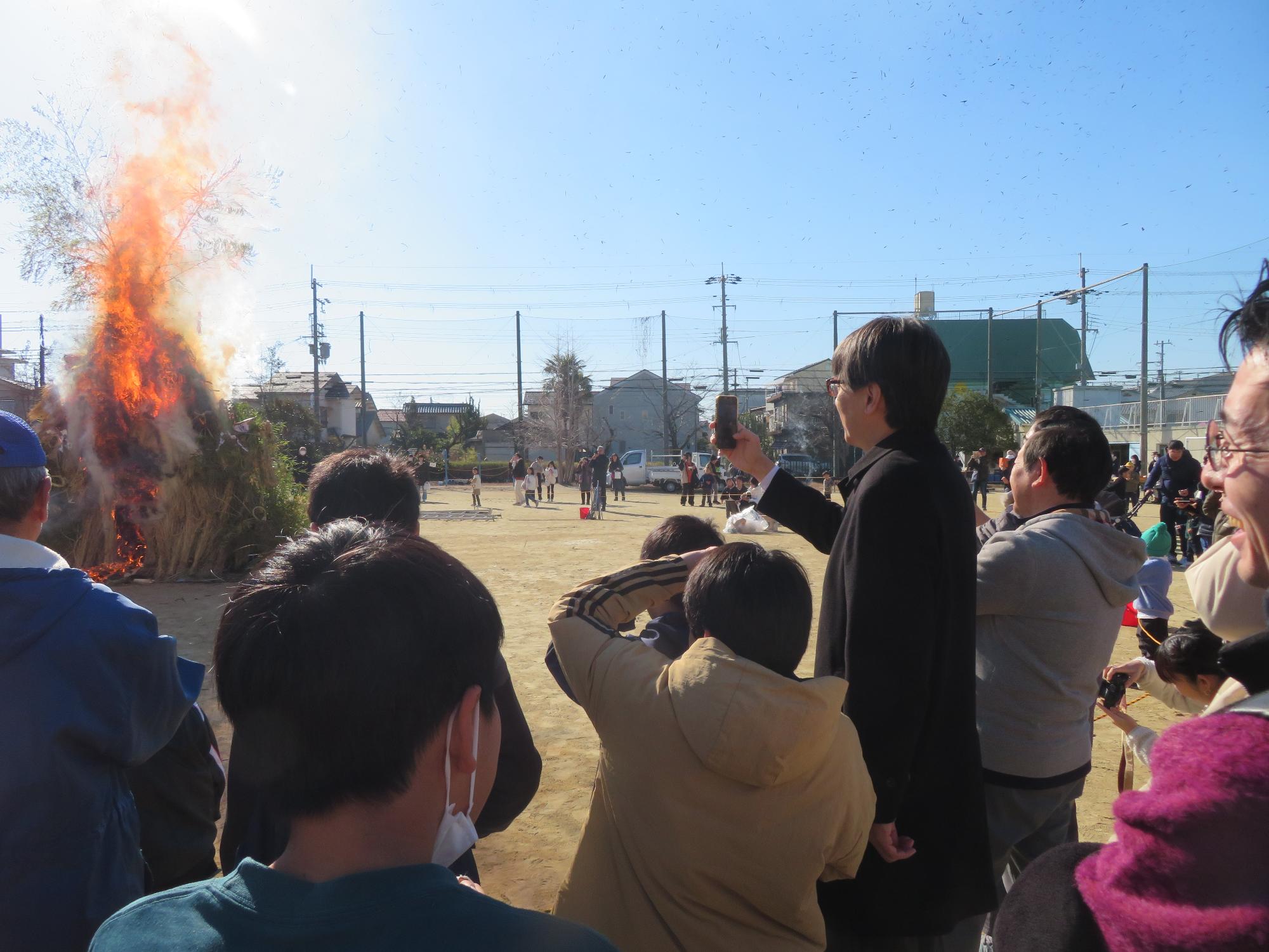 とんど焼きの写真を撮る市長の写真