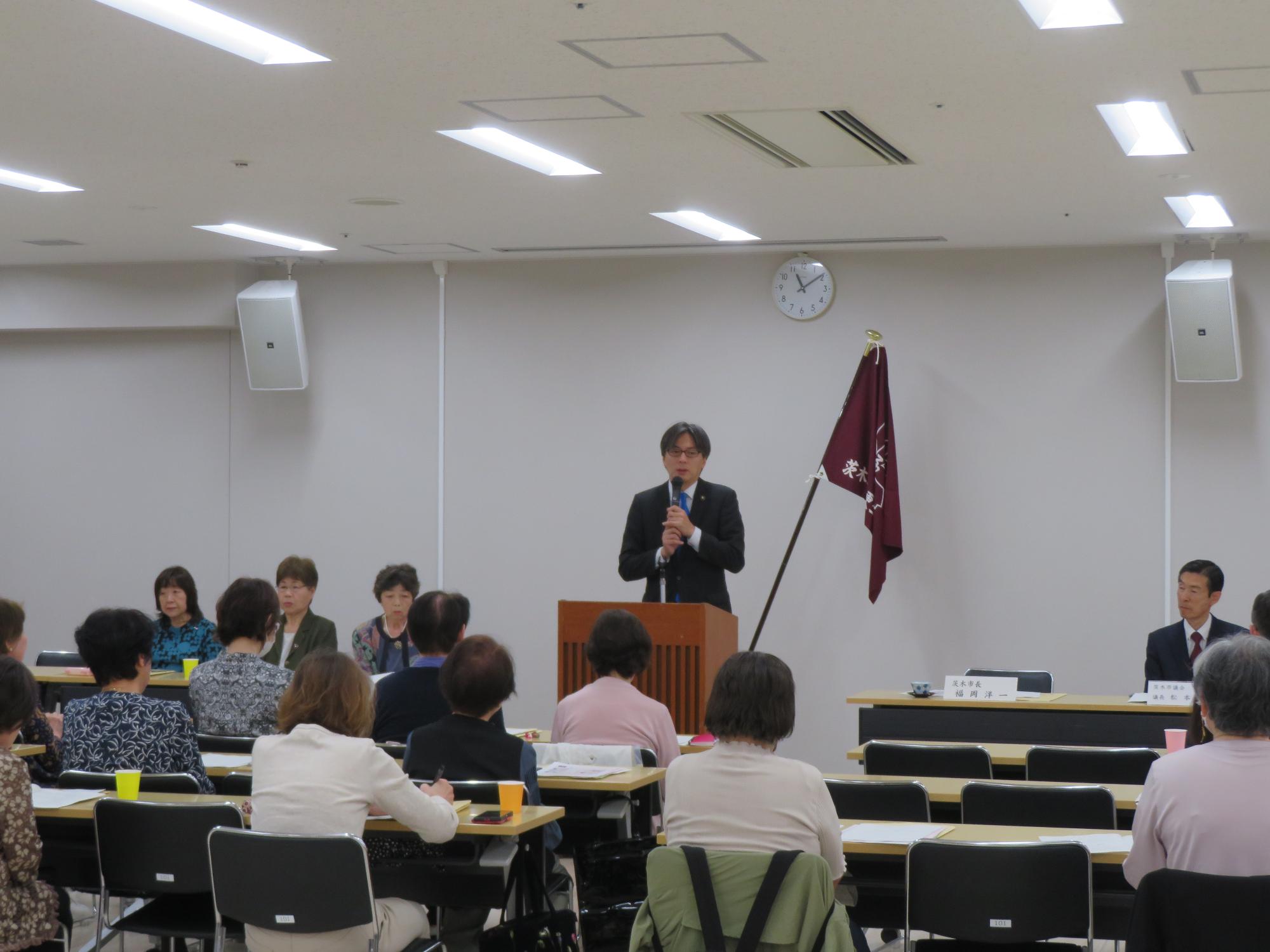 参加者の前であいさつをする市長の写真