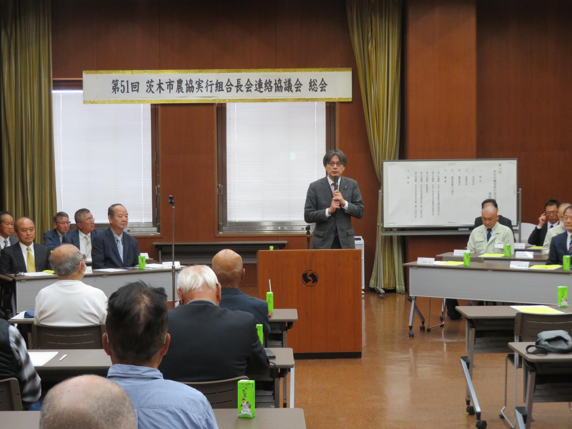 出席者の前であいさつをする市長の写真