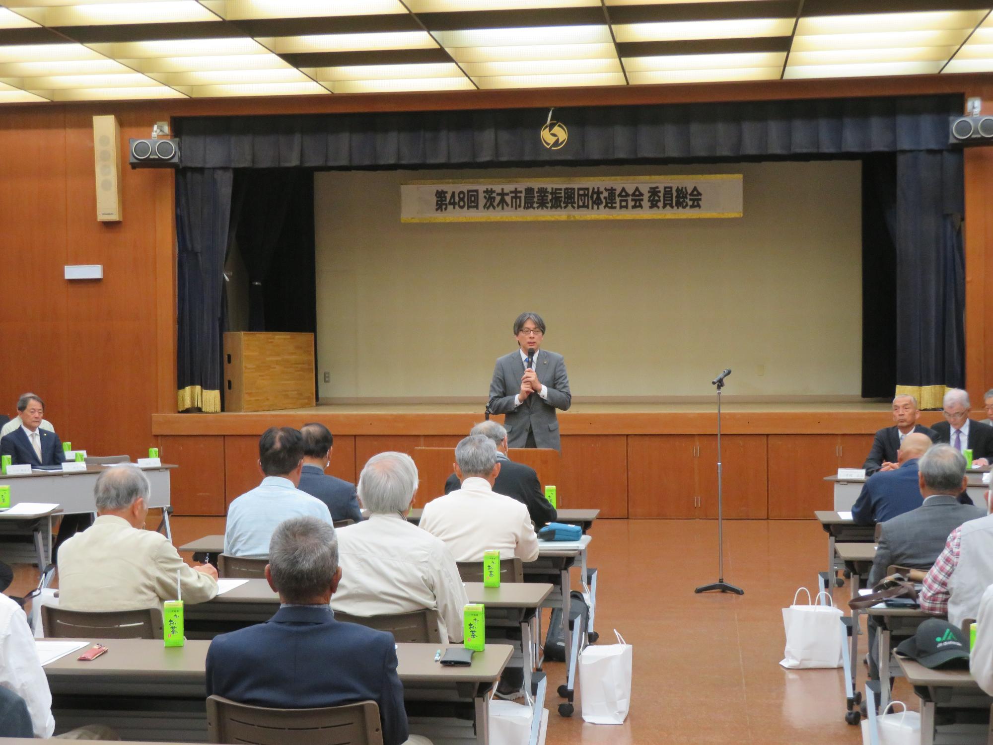 出席者の前であいさつをする市長の写真