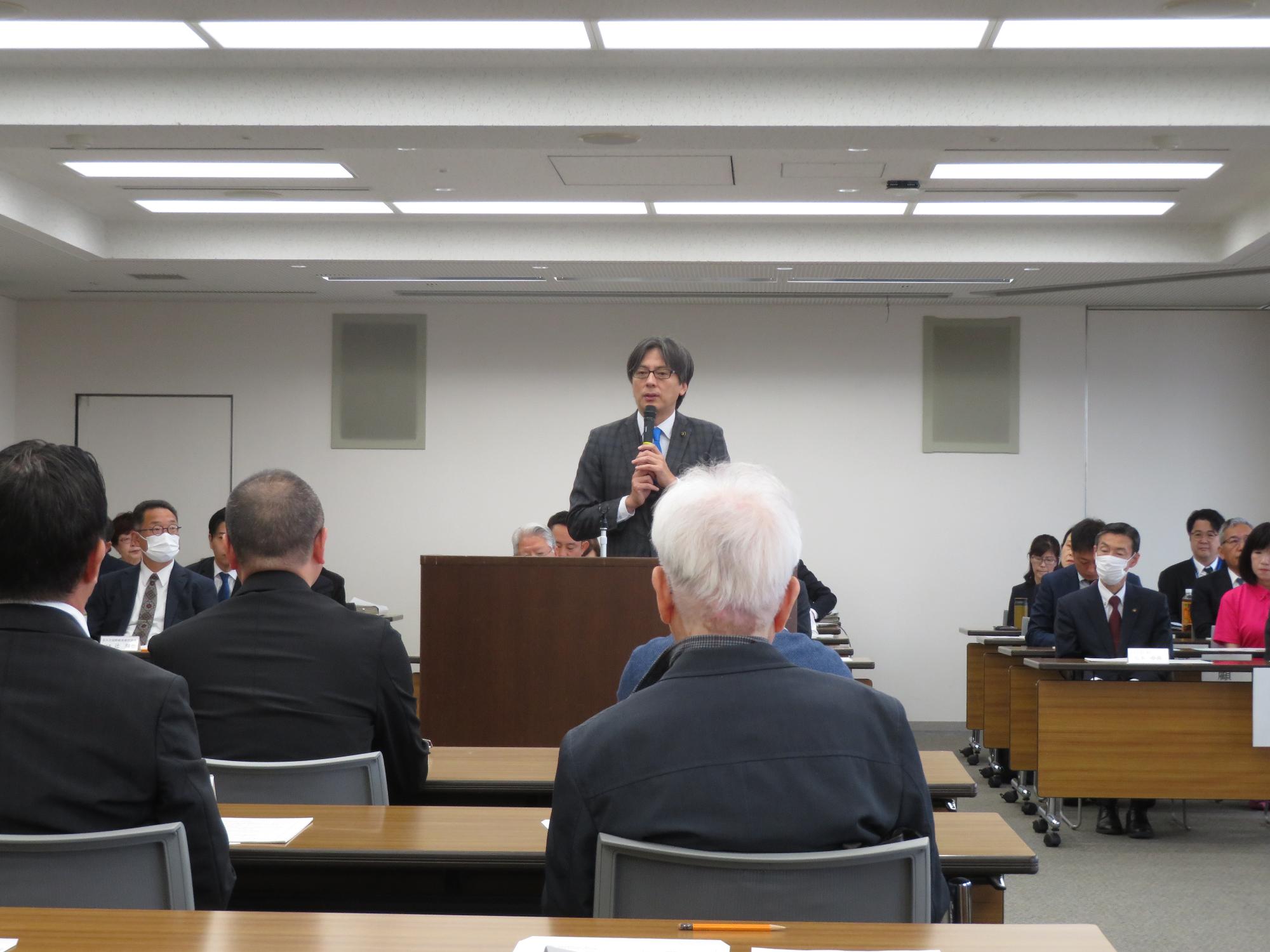 演台であいさつをする市長の写真