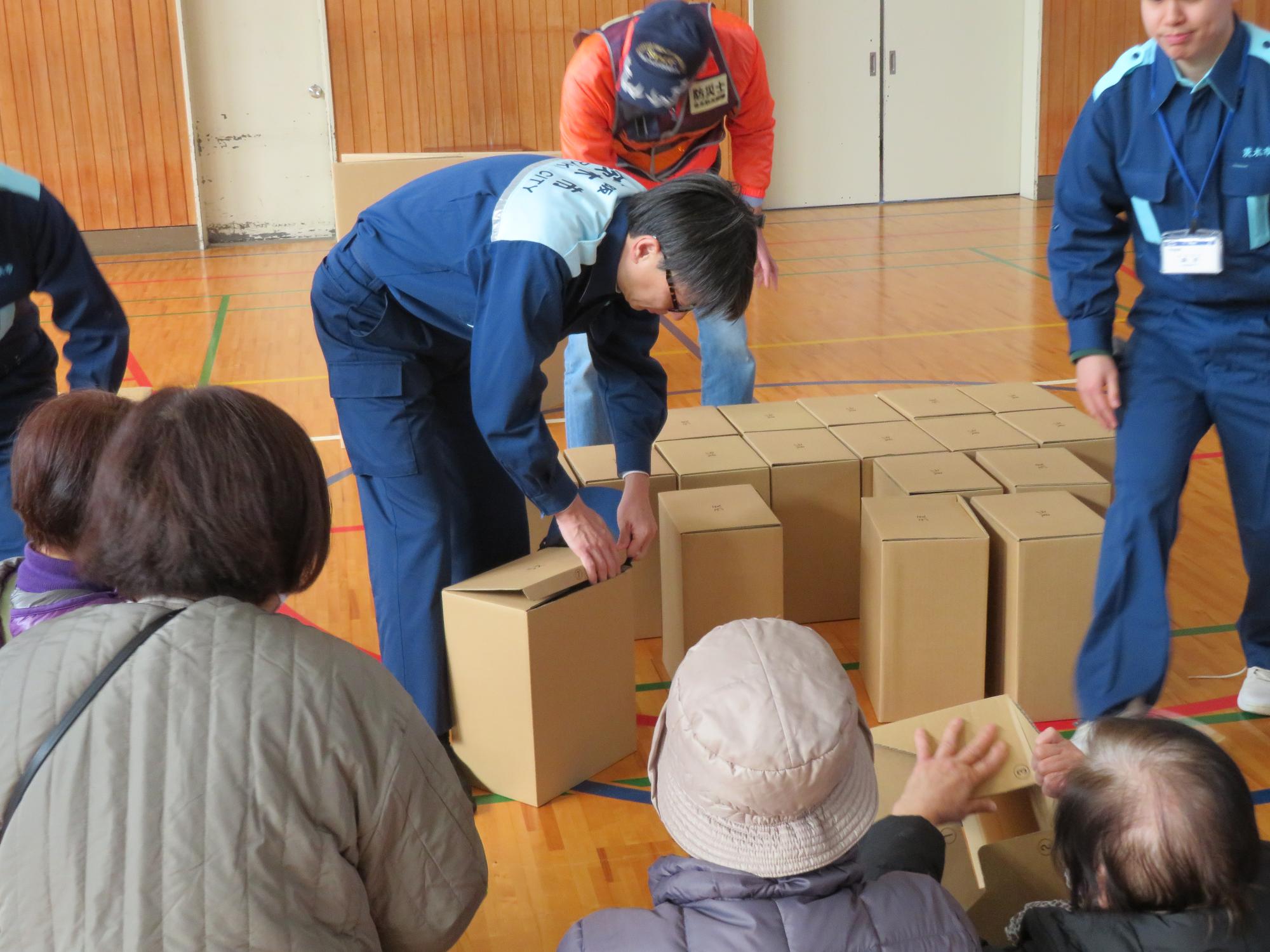 ダンボールベッドを組み立てる市長の写真