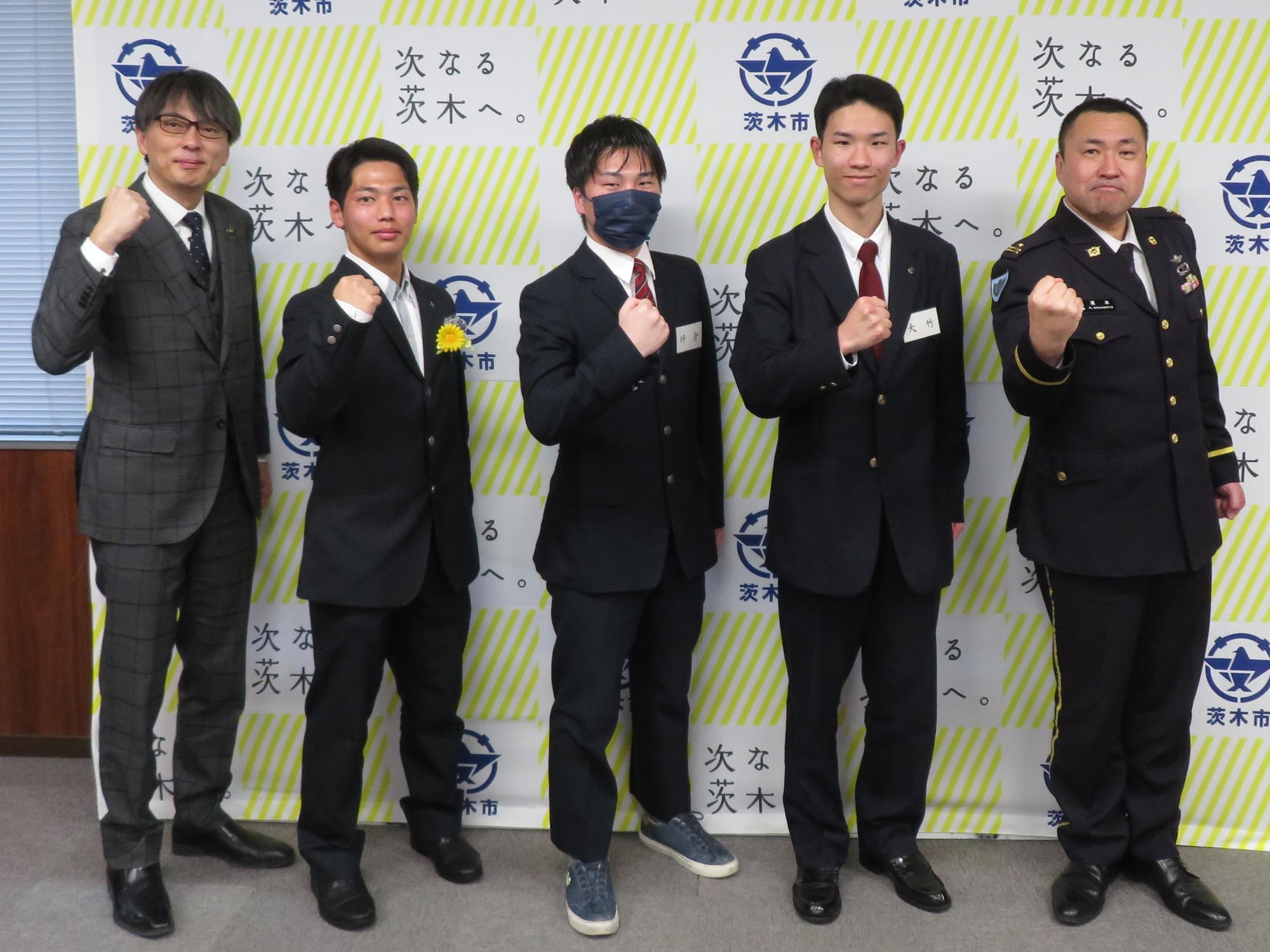 ガッツポーズをする入隊・入校予定者、関係者と市長の写真