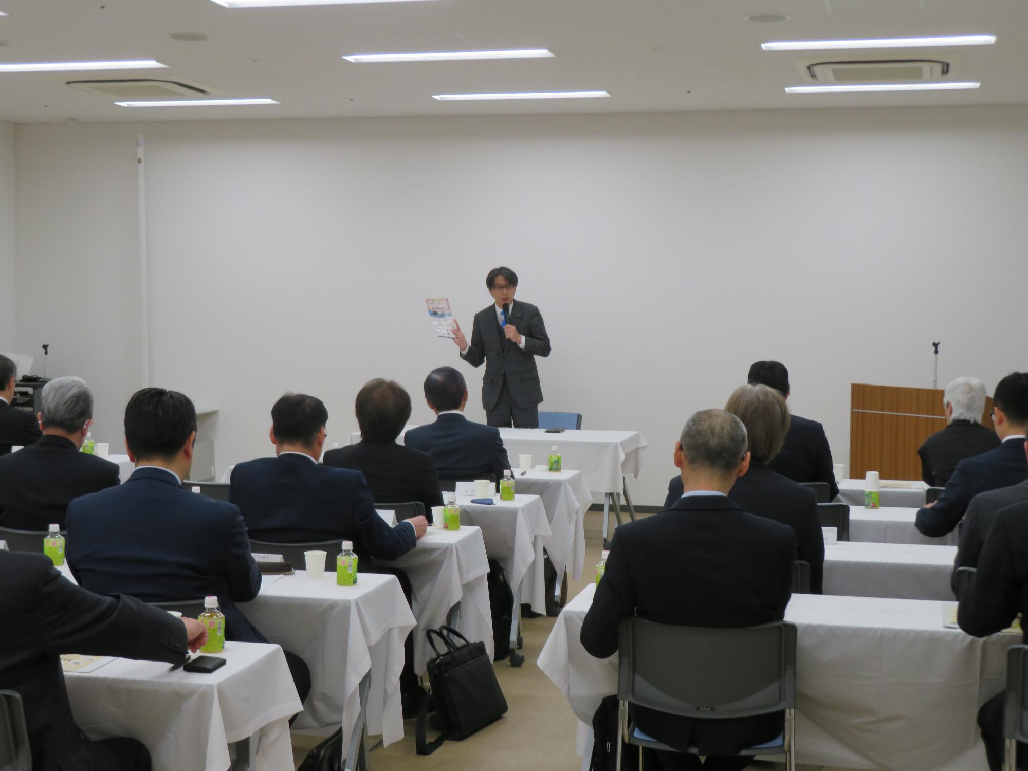 出席者の前で講話をする市長の写真