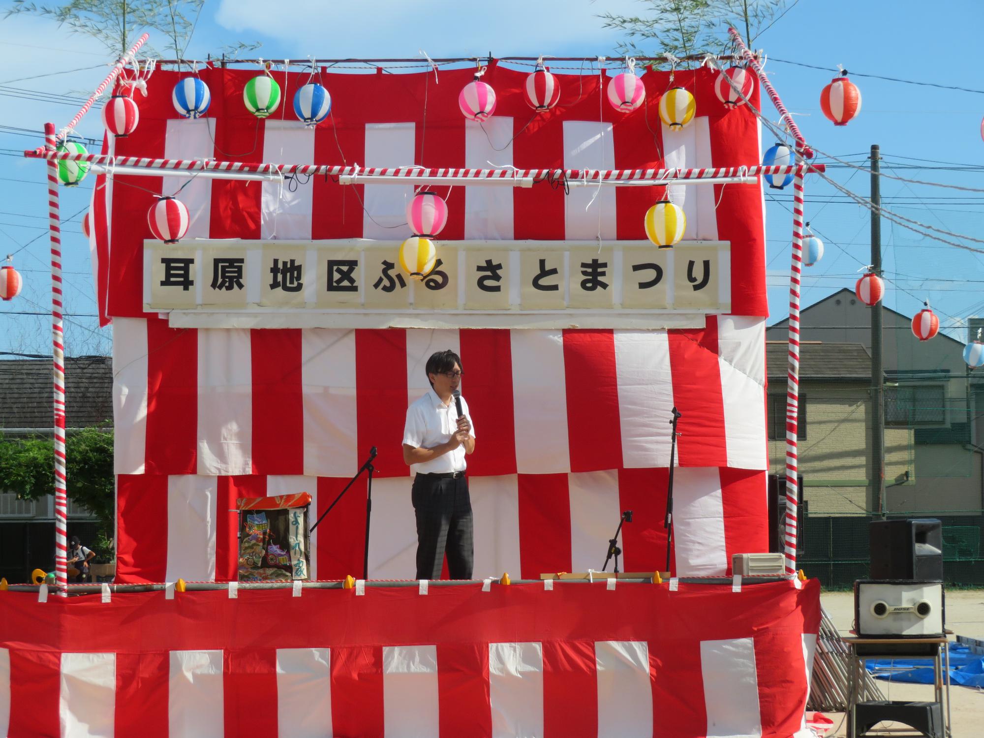 お祭りで来場者にあいさつする市長の写真